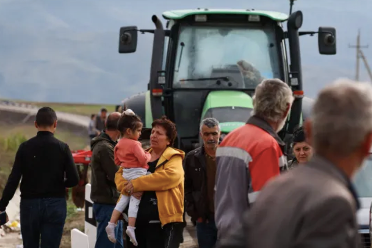 Refugees wait next to a line of vehicles near the border town of Kornidzor, Armenia, arriving from Nagorno-Karabakh, on Sept. 26.