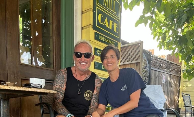 Jeff and his wife and his dog in front of a cafe in Hawaii