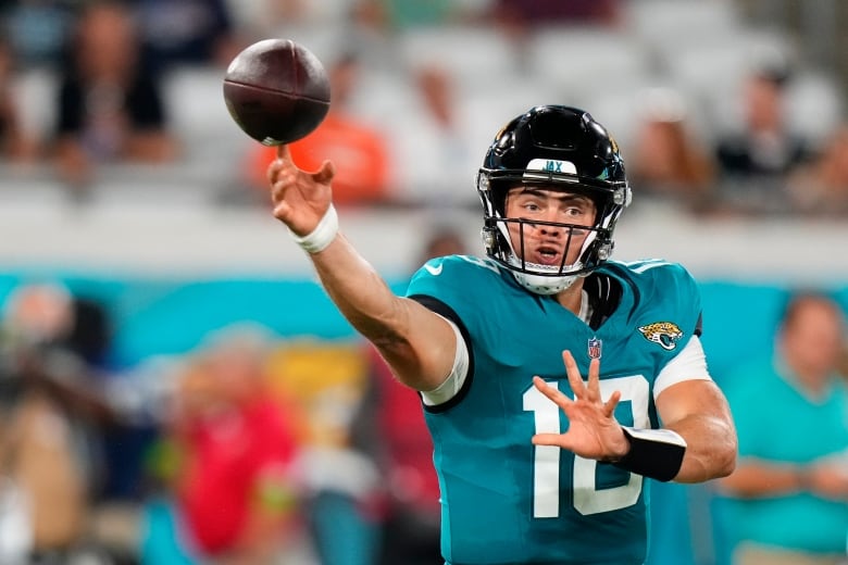 A male football player is seen throwing a ball mid-game.