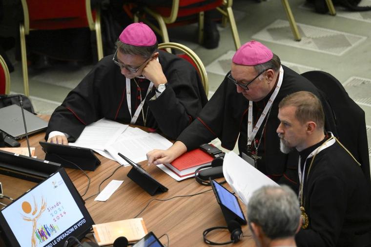 Delegates vote to approve a synthesis report at the conclusion of the Synod on Synodality on Oct. 28.