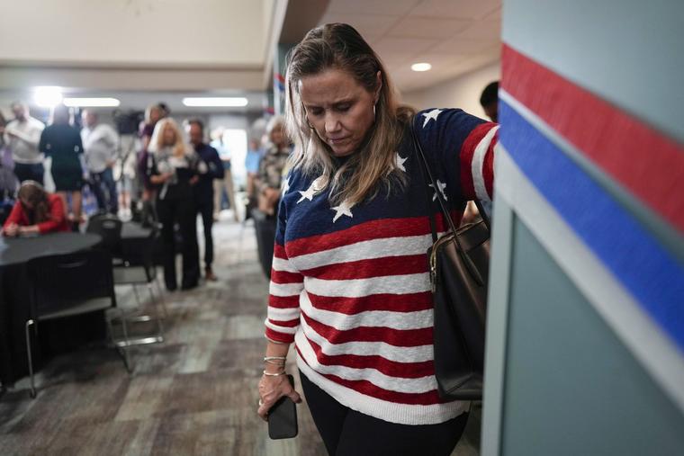 A woman bows her head during a prayer at a watch party for opponents of Issue 1 at the Center for Christian Virtue in Columbus, Ohio, Tuesday, Nov. 7, 2023.