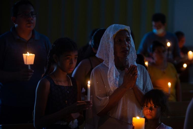 Worshippers hold candles during an Easter vigil Mass at the Metropolitan Cathedral in Managua, Nicaragua, Saturday, April 8, 2023.