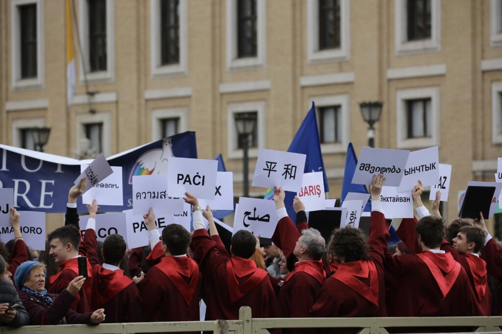 Pilgrims gathered in St. Peter's Square for Pope Francis' Angelus reflection on Jan. 1, 2024, wave peace signs. On Jan. 1 the Catholic Church observes the Solemnity of Mary, Mother of God, as well as the World Day of Peace. Credit: Elizabeth Alva/CNA