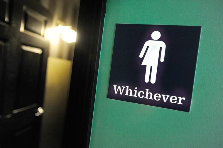 A gender-neutral sign is posted outside a bathroom on May 11, 2016, in Durham, North Carolina.