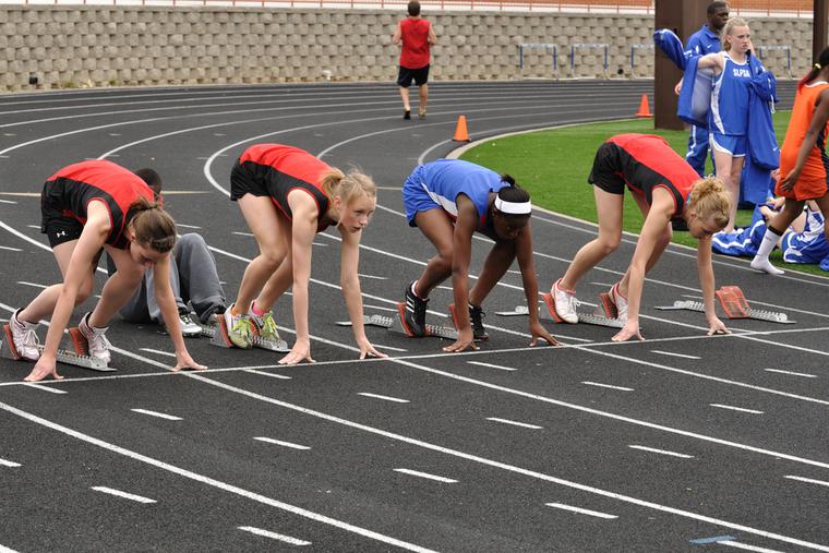 Teenage girls set to race in a track meet.
