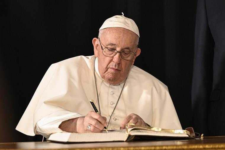 Pope Francis signs the honor book in Belem Presidential Palace in Lisbon, Portugal on Aug. 2, 2023.