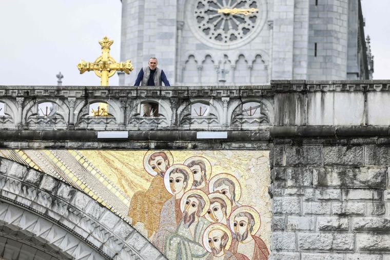 A pedestrian looks on next to gigantic mosaics, made by artist and priest Marko Rupnik, displayed on the Notre-Dame-du-Rosaire Basilica in the Sanctuary of Lourdes, in Lourdes, southwestern France. The bishop of Lourdes says that he has received a 'pile of letters' from Catholics all over the world as he considers whether to remove the shrine’s mosaics by alleged abuser Father Marko Rupnik. Bishop Jean-Marc Micas of Tarbes and Lourdes says that he hopes to make a decision this spring. The bishop formed a special commission last year to determine the future of the Rupnik mosaics.