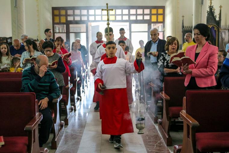 Palestinian Christians celebrate Easter Sunday Mass at Holy Family Church in Gaza City on March 31, amid the ongoing battles Israel and the Hamas militant group.