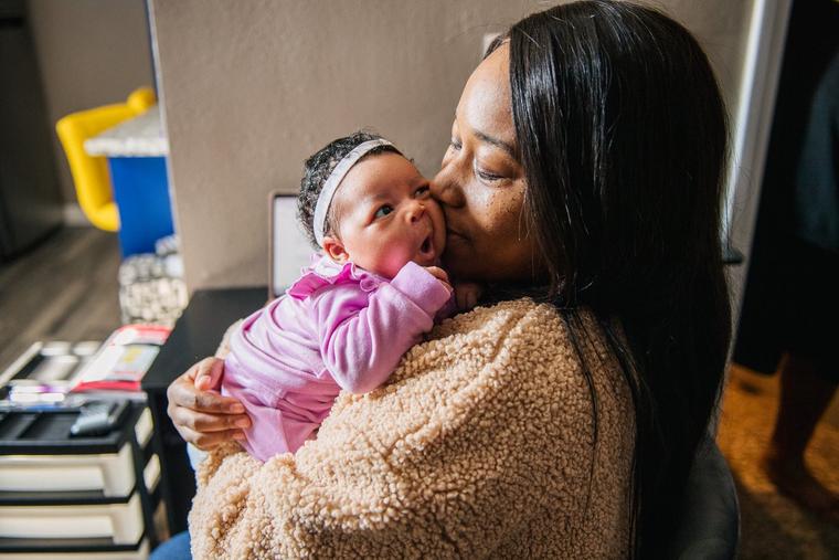 Alexis Small kisses her newborn, Aubrielle, in Los Angeles.