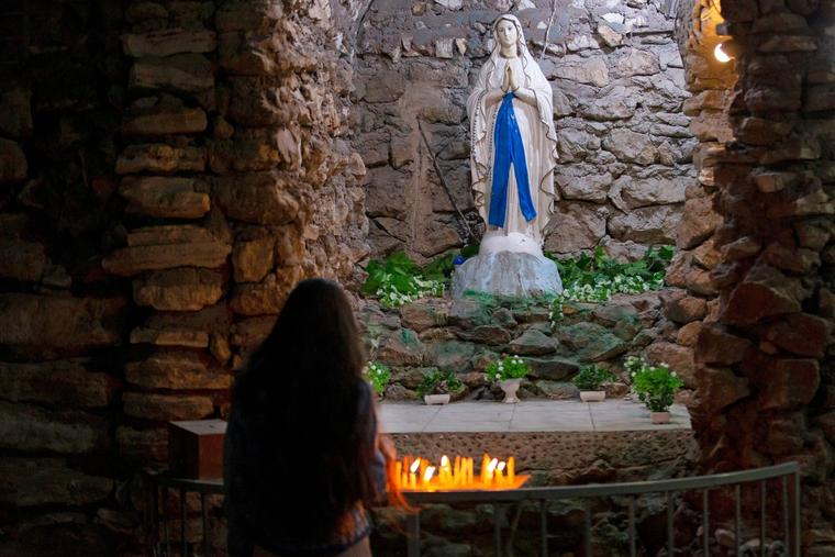 An Iraqi worshipper lights a candle in front of a statue of the Virgin Mary at the Church of St. Theresa, in the southern city of Basra.