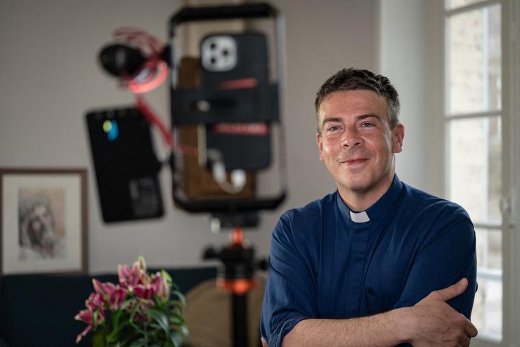 Father Matthieu Jasseron, priest of Saint Jean-Baptiste de Joigny parish, poses at his home in Joigny, central France, on Feb. 24, 2023.