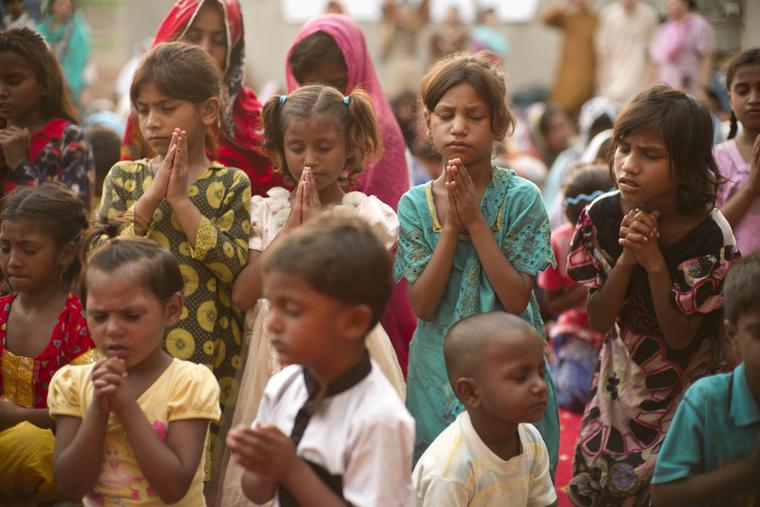 Children in Lahore, Pakistan pray together.