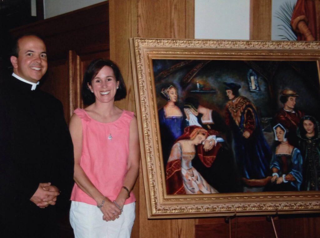 Father Marcel Taillon poses with artist Sharon Clossick as she presents the protrait of St. Thomas Imprisoned, now gracing the right side of the altar at St. Thomas More Catholic Church.