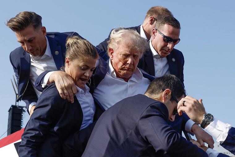 Republican presidential candidate and former president Donald Trump is rushed offstage by U.S. Secret Service agents after being grazed by a bullet during a rally Saturday in Butler, Pennsylvania. Butler County District Attorney Richard Goldinger said the shooter is dead after injuring Trump, killing at least one audience member and injuring at least another in the shooting.