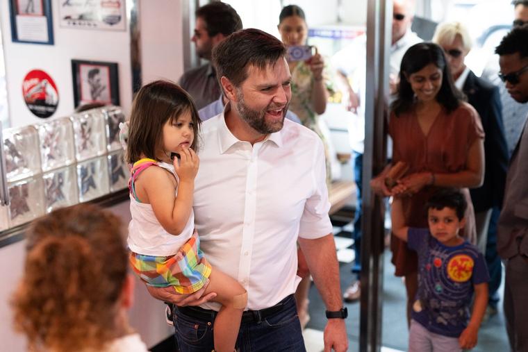 Republican vice-presidential nominee JD Vance carries his daughter, Maribel, as he arrives to greet supporters at the Park Diner on July 28 in St. Cloud, Minnesota.