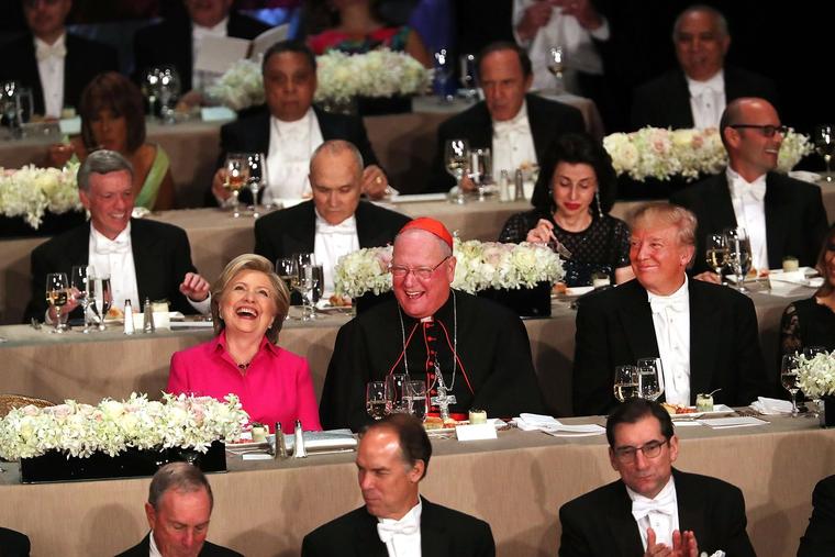 Cardinal Timothy Dolan sits between Hillary Clinton and Donald Trump at the annual Alfred E. Smith Memorial Foundation Dinner at the Waldorf Astoria on October 20, 2016, in New York City.