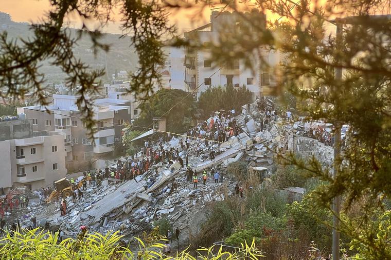 First responders inspect the rubble of a building after an Israeli airstrike in the southern Lebanese village of Ain El Delb on Sept. 29.