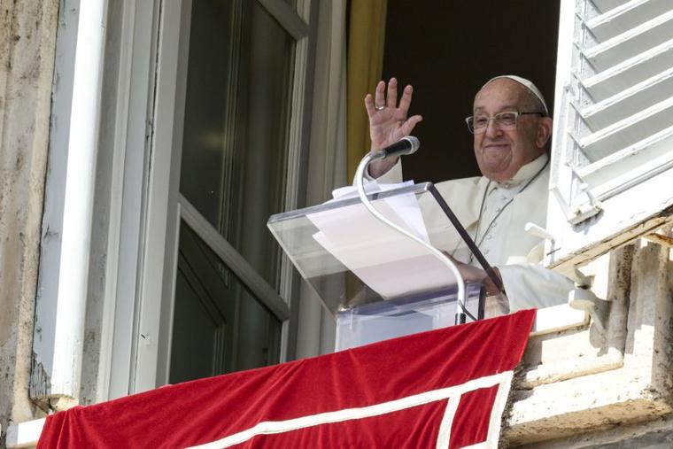 Pope Francis waves to pilgrims gathered in St. Peter's Square for his Angelus reflection on Oct. 6.