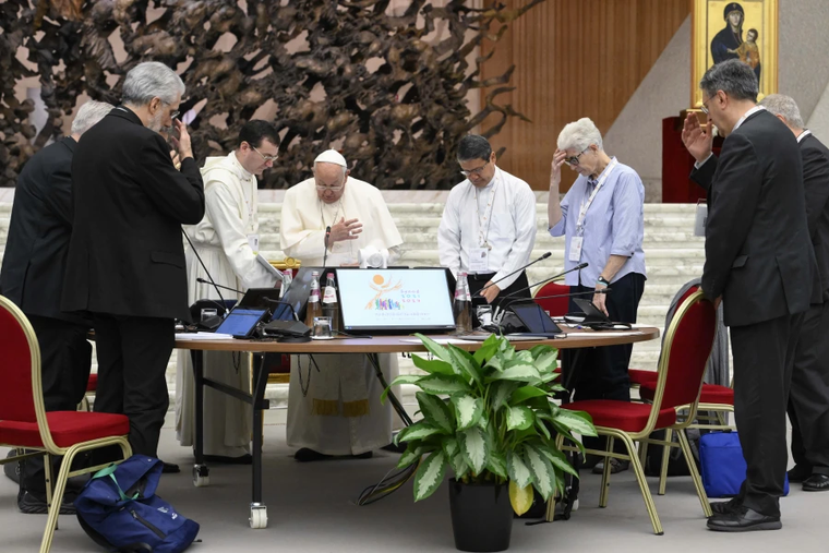Pope Francis prays with members of the Synod on Synodality during one of its meetings in the Vatican's Paul VI Hall on the morning of Oct. 12.