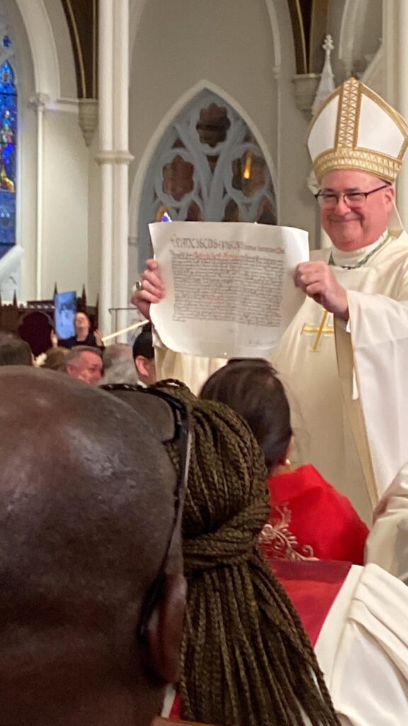 Archbishop Richard Henning shows his appointment letter Oct. 31, 2024