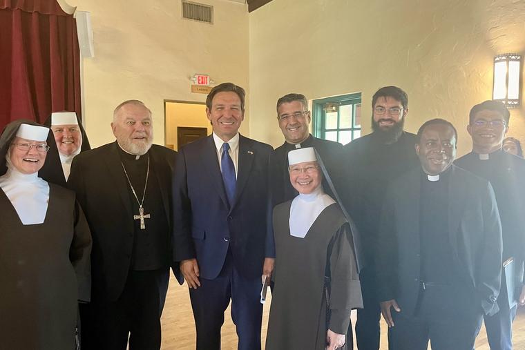 Archbishop Thomas Wenski of Miami and Governor Ron DeSantis stand alongside priests and religious sisters at the Little Flower School in Coral Gables October 21, 2024.