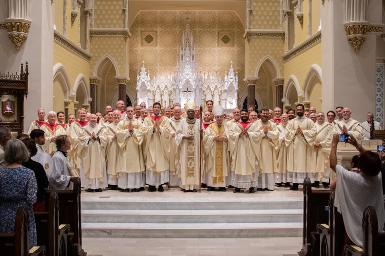 Bishop Jacques Fabre-Jeune poses alongside many of the priests of the Diocese of Charleston at a recent ordination. The diocese has seen a recent surge in vocations.