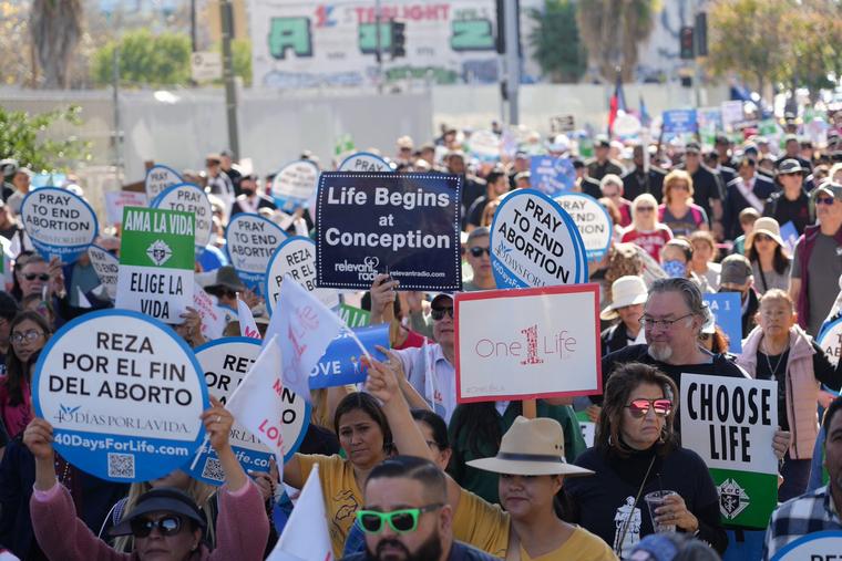 Participants hold signs proclaiming the dignity of life at OneLife LA 2023.