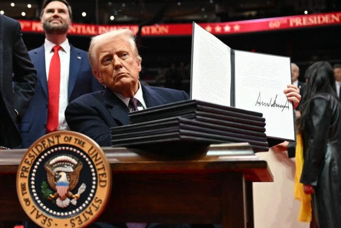 President Donald Trump holds an executive order he just signed during the inaugural parade inside Capital One Arena in Washington, D.C., on Jan. 20, 2025.