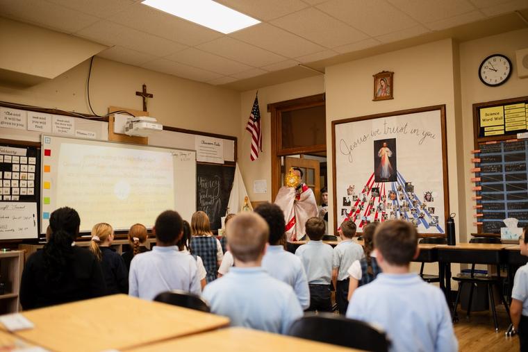 Students kneel before the Blessed Sacrament at St. Agnes School in St. Paul, Minnesota.