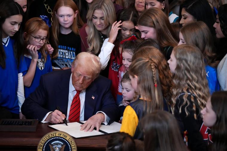 U.S. President Donald Trump, joined by women athletes, signs an executive order in the East Room at the White House on Feb. 5, 2025, in Washington. The executive order, which Trump signed on National Girls and Women in Sports Day, prohibits transgender women from competing in female sports.