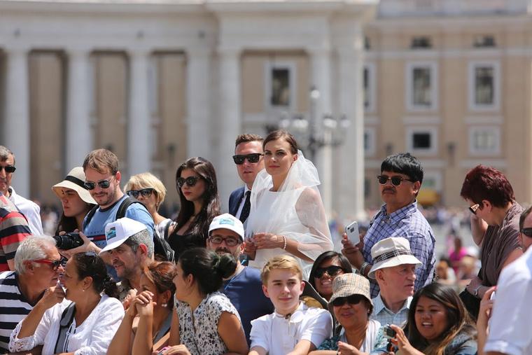 A married couple in wedding attire in St. Peter’s Square await a blessing from Pope Francis on June 24, 2015.
