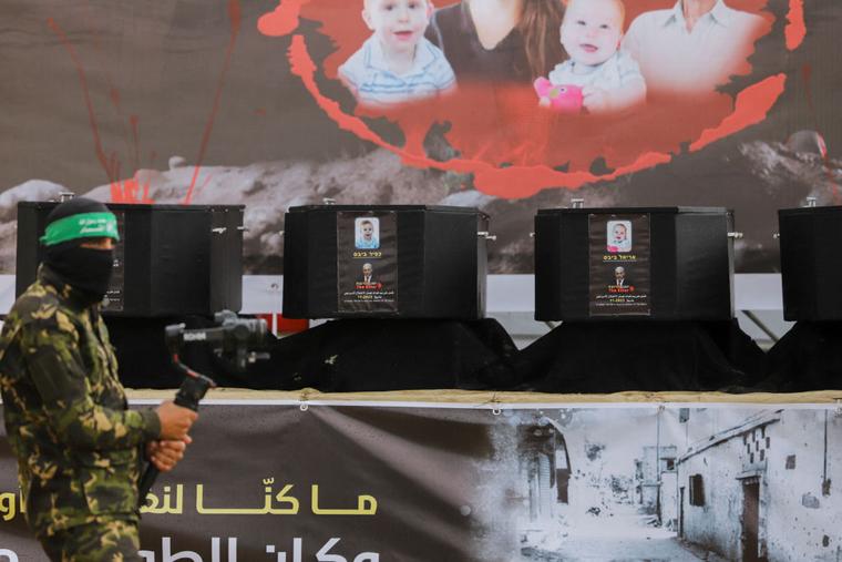 The coffins of the four Israeli hostages sit on stage before handing them over to the Red Cross in Khan Yunis in southern Gaza on Feb. 20, 2025. Hamas handed over the bodies of four Israeli hostages, including those of the Bibas family mother and two young sons.
