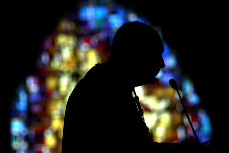 Theodore McCarrick is silhouetted against a stained-glass window Oct. 5, 2002, at St. Mary’s Church in Rockville, Maryland.