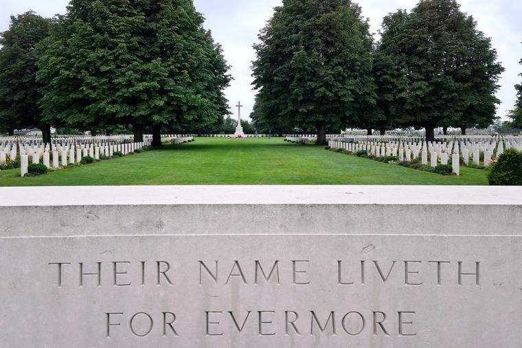 A stone marker bearing the inscription “Their Name Liveth Forevermore” stands among the graves of fallen soldiers at the Normandy American Cemetery and Memorial in Colleville-sur-Mer, France. The cemetery overlooks Omaha Beach and honors the 9,388 American servicemembers who gave their lives during the D-Day landings and subsequent operations in World War II.