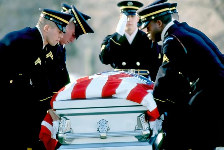 A burial detail lowers the flag-draped casket of Specialist Alejandro L. Manrique, a U.S. Army soldier killed during the U.S. invasion of Panama, to his final resting place with full military honors on Dec. 28, 1989.