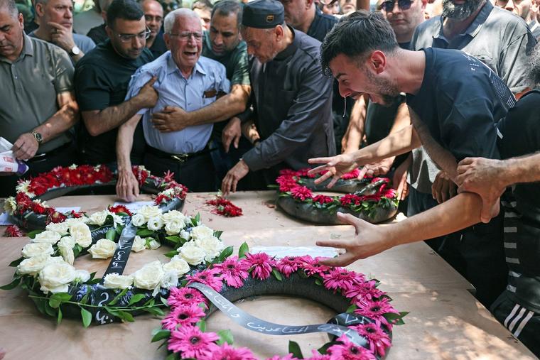 Friends and family mourn during a June 17 funeral in Tamra for four Christian women killed when an Iranian missile destroyed a three-story building in the northern Arab-Israeli city. The June 14 strike claimed the lives of Manar al-Qassem Abu al-Hija Khatib, 39; her daughters Hala, 13, and Shada, 20; and their relative Manar Diab Khatib, 41. Dozens more were wounded.