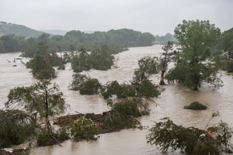 Trees emerge from floodwaters along the Guadalupe River on July 4, 2025, in Kerrville, Texas. Heavy rainfall caused flooding along the Guadalupe River in central Texas with numerous fatalities reported.