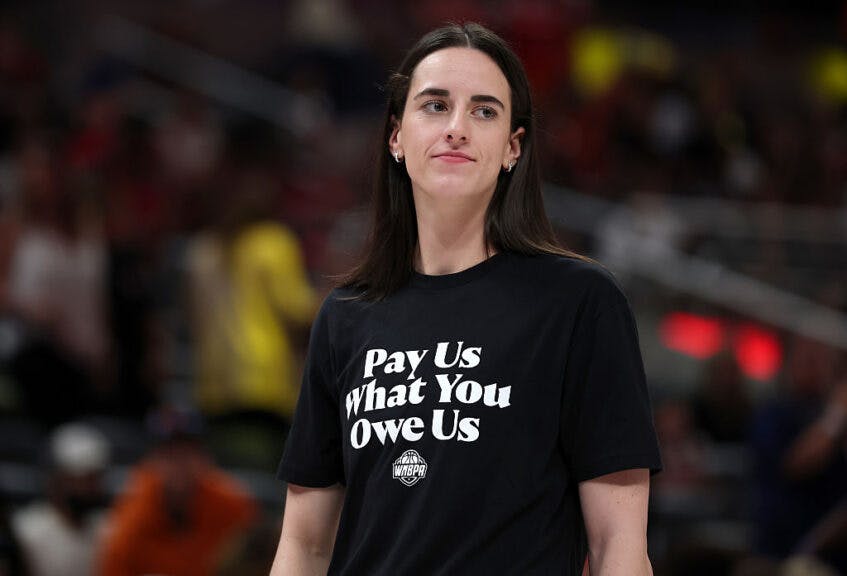 Caitlin Clark #22 of the Indiana Fever wears a shirt saying "Pay us what you owe us" prior to the 2025 AT&T WNBA All-Star Game at Gainbridge Fieldhouse on July 19, 2025 in Indianapolis, Indiana.