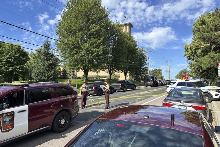 Law enforcement officers gather outside Annunciation Church's school in response to a reported mass shooting, Aug. 27, 2025, in Minneapolis.