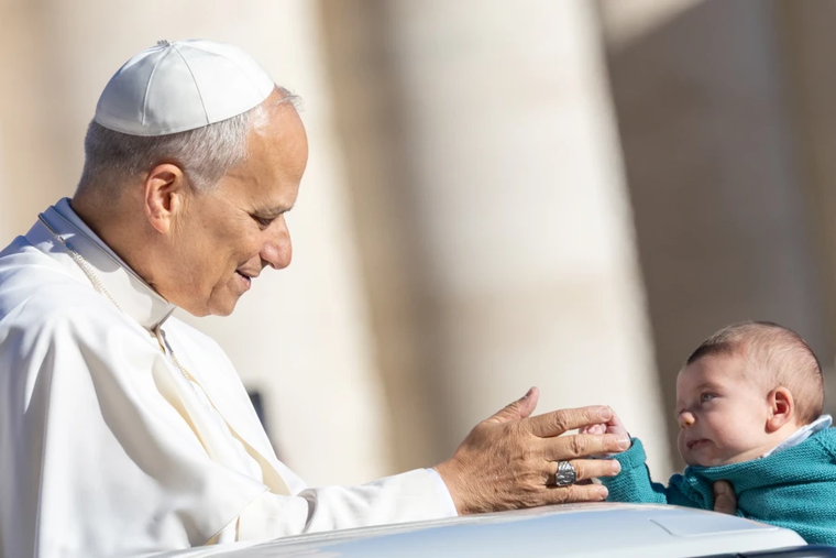 Pope Leo XIV greets a baby at his general audience in St. Peter's Square at the Vatican, Wednesday, Oct. 8, 2025.
