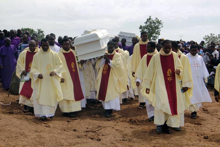 Coffins holding the bodies of priests killed by Fulani herdsmen are carried to the burial site at Ayati-Ikpayongo in Gwer East District of Benue State, north-central Nigeria, on May 22, 2018.