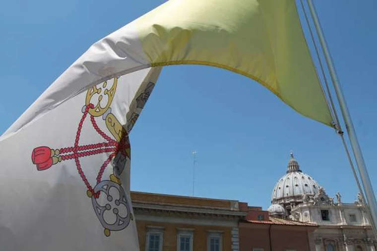 A Vatican flag waves over the dome of St. Peter’s Basilica.