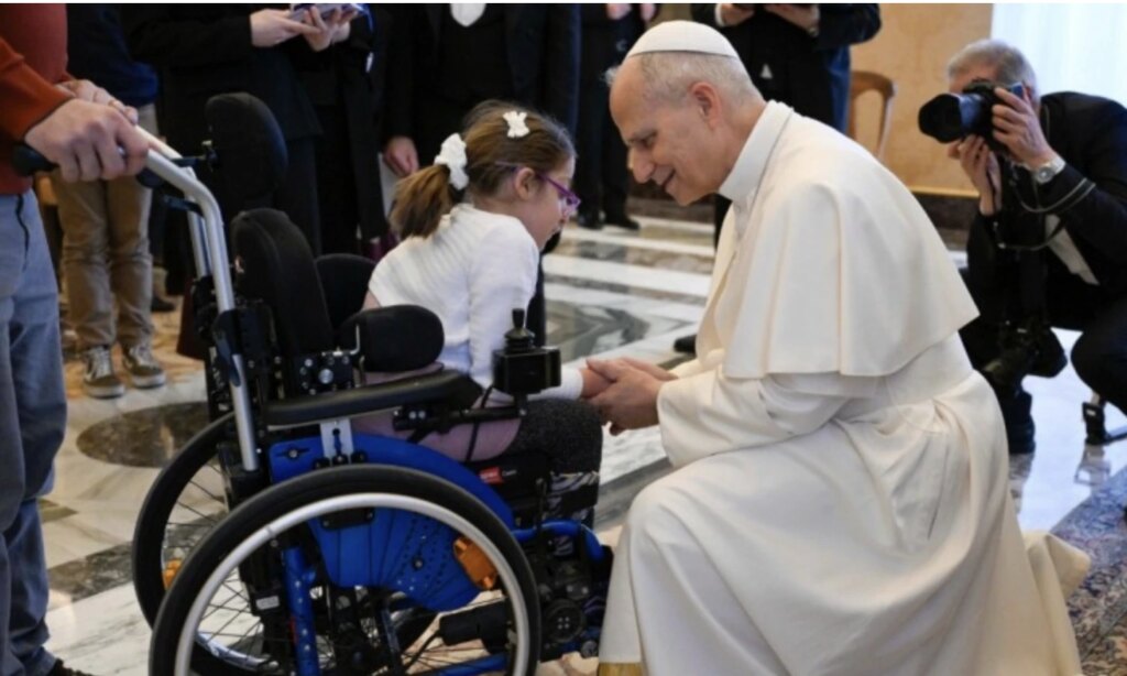The pope greets a girl in a wheelchair during the audience. Credit: Vatican Media