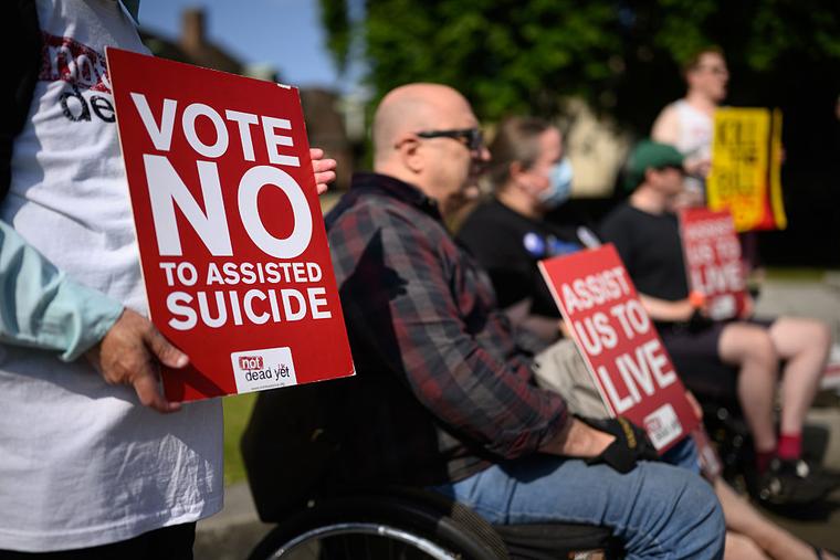 A placard reading 'Vote No to Assisted Suicide' is displayed during a protest by disability campaigners who oppose the Terminally Ill Adults (End of Life) Bill, at Old Palace Yard on June 13, 2025 in London, England.