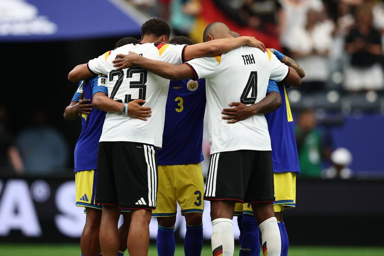 Felix Nmecha (Germany) and Jonathan Tah (Germany) pray with players from Curaçao after the German team’s 7-1 first-day Group E FIFA World Cup win on June 14, 2026, in Houston.
