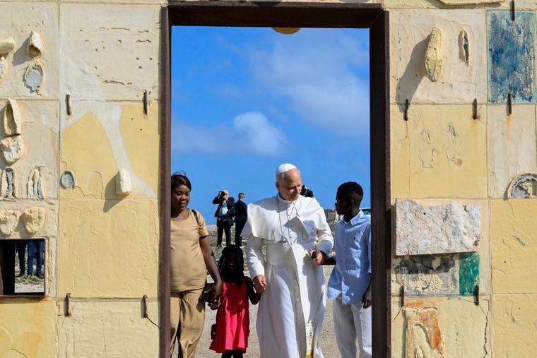 Pope Leo XIV with a family of migrants at the Gateway to Europe monument, which commemorates migrants lost in the Mediterranean, on the Italian island of Lampedusa on July 4, 2026.