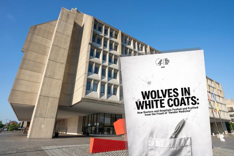 The cover of the Department of Health and Human Services’ new report, “Wolves in White Coats,” is seen against the Hubert H. Humphrey Building, the agency’s headquarters in Washington.
