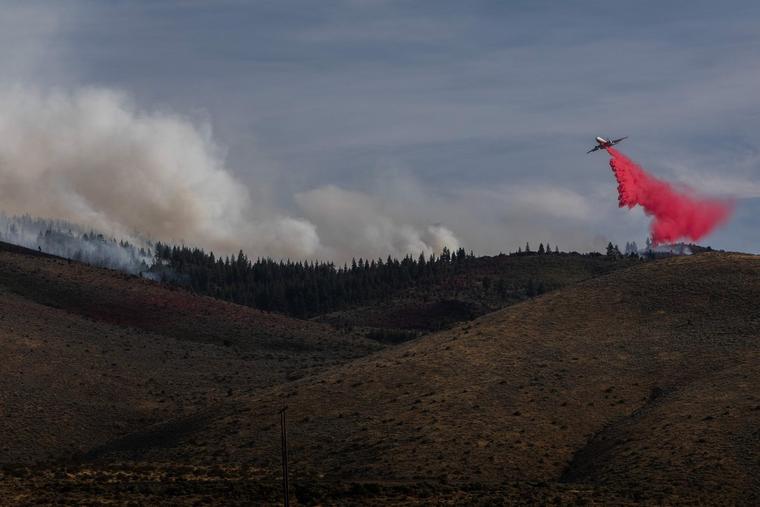 A firefighting aircraft drops fire retardant during the Hawk Fire on Aug. 23, 2026, in Reno, Nevada. The wildfire spread from the Sierra foothills toward Reno, forcing thousands to evacuate their homes.