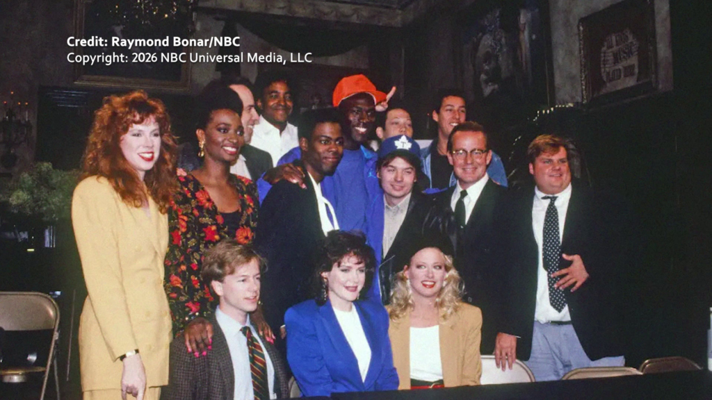 Chris Farley (R) and Siobhan Fallong Hogan (L) pose alongside the entire Saturday Night Live cast in the 1990s.